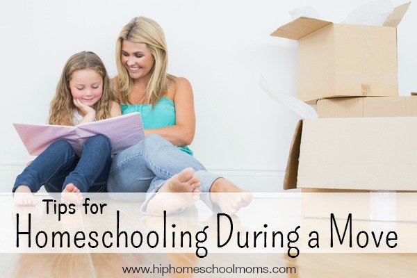 Mother and daughter reading a book together on the floor near moving boxes