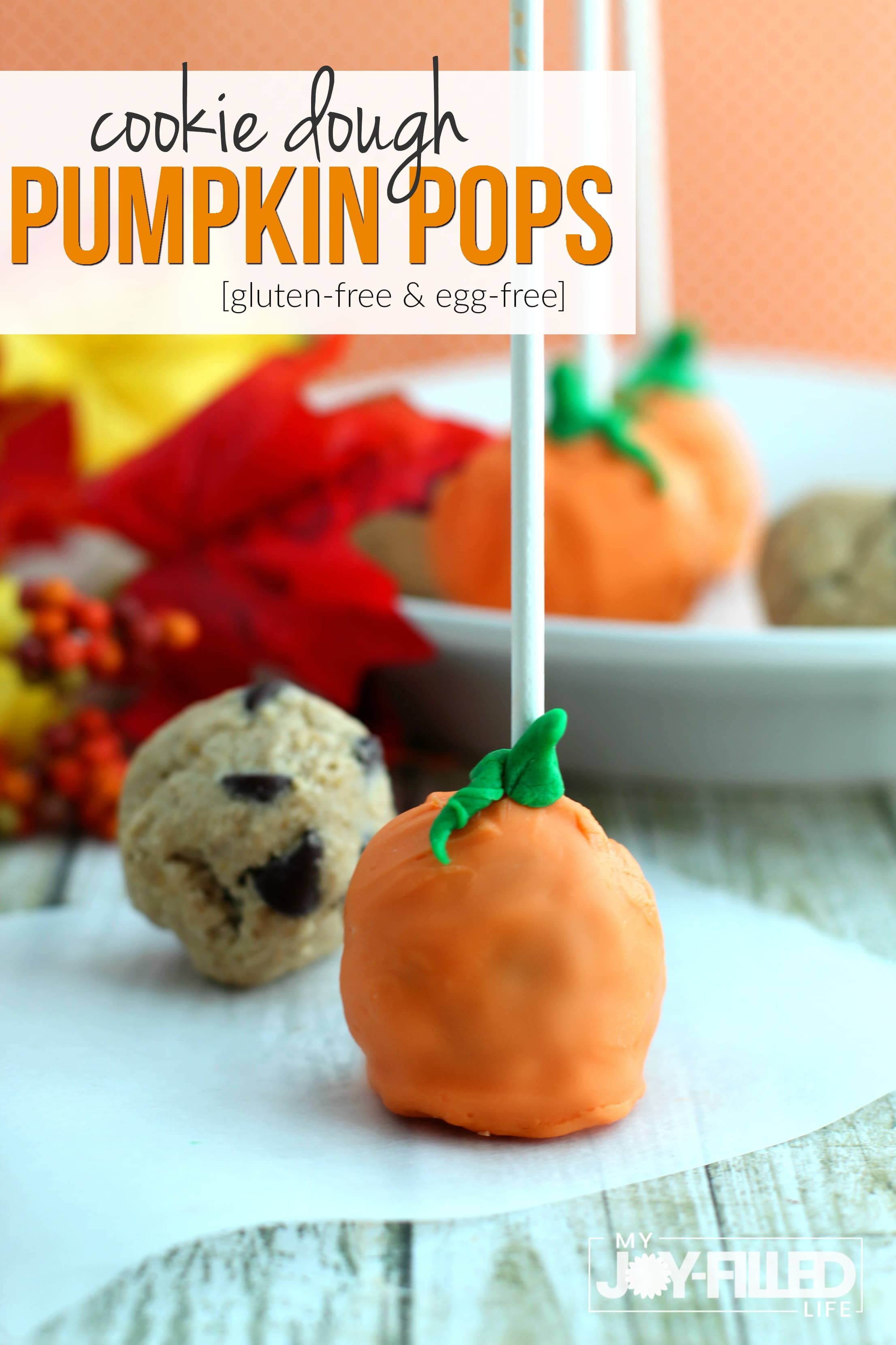 These cookie dough pumpkin pops are the perfect gluten-free, egg-free treat for your next fall or harvest party. Food is better on a stick. #cookiedough #glutenfree #pumpkinpops #falltreat #harvestparty