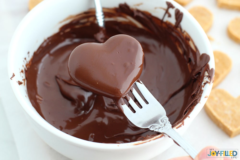 Dip hearts into chocolate for homemade copycat Reese's hearts