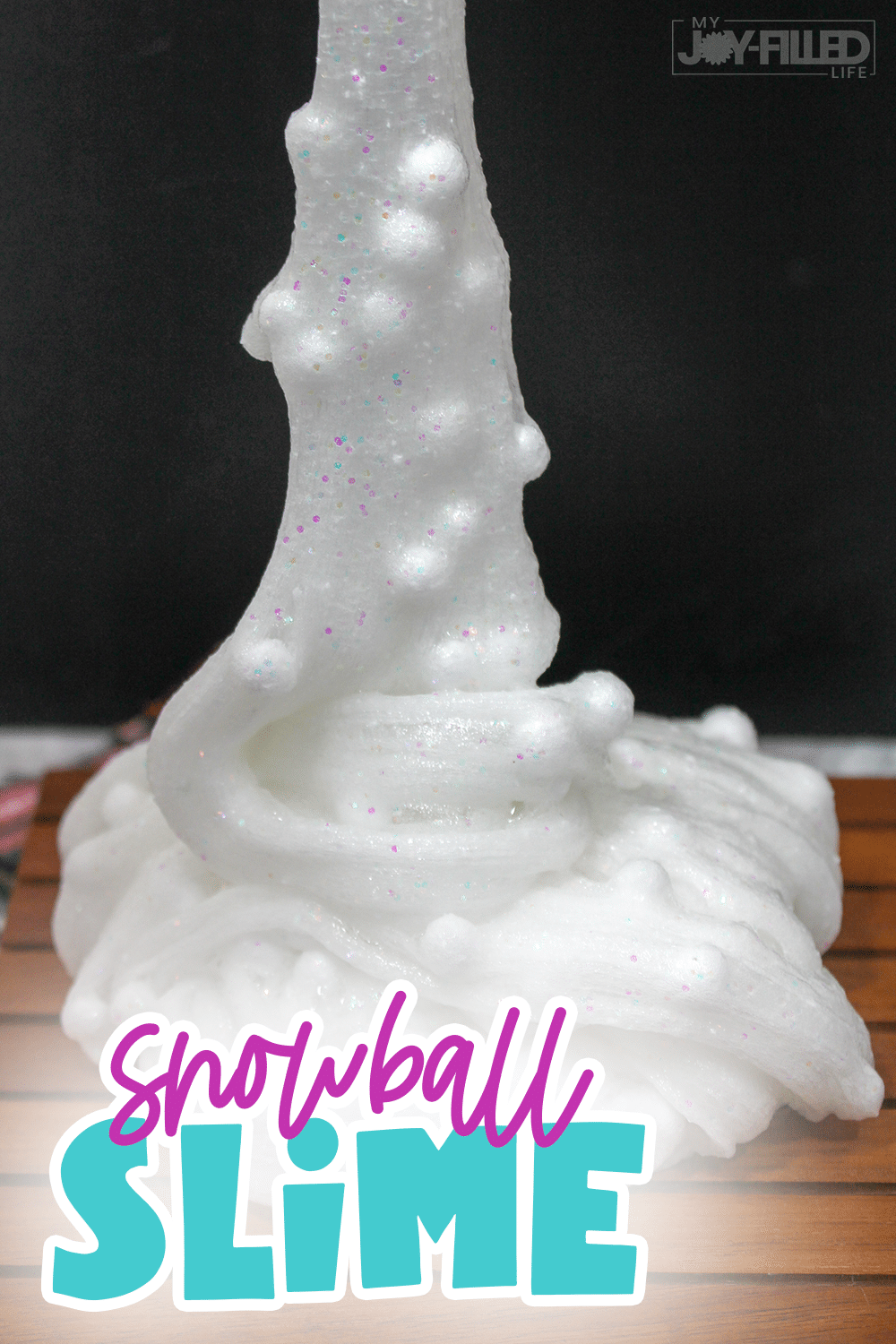 This snowball slime is the perfect indoor activity during the winter months. It is sure to keep kids occupied while being stuck inside due to cold weather! #slime #slimerecipe #snowballslime #sensoryplay