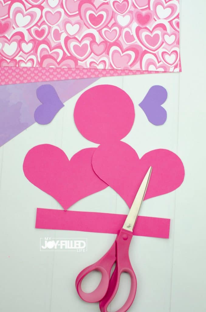Pink and purple hearst and shapes cut out with scissors for Valentine craft