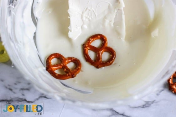dipping pretzels in melted white chocolate