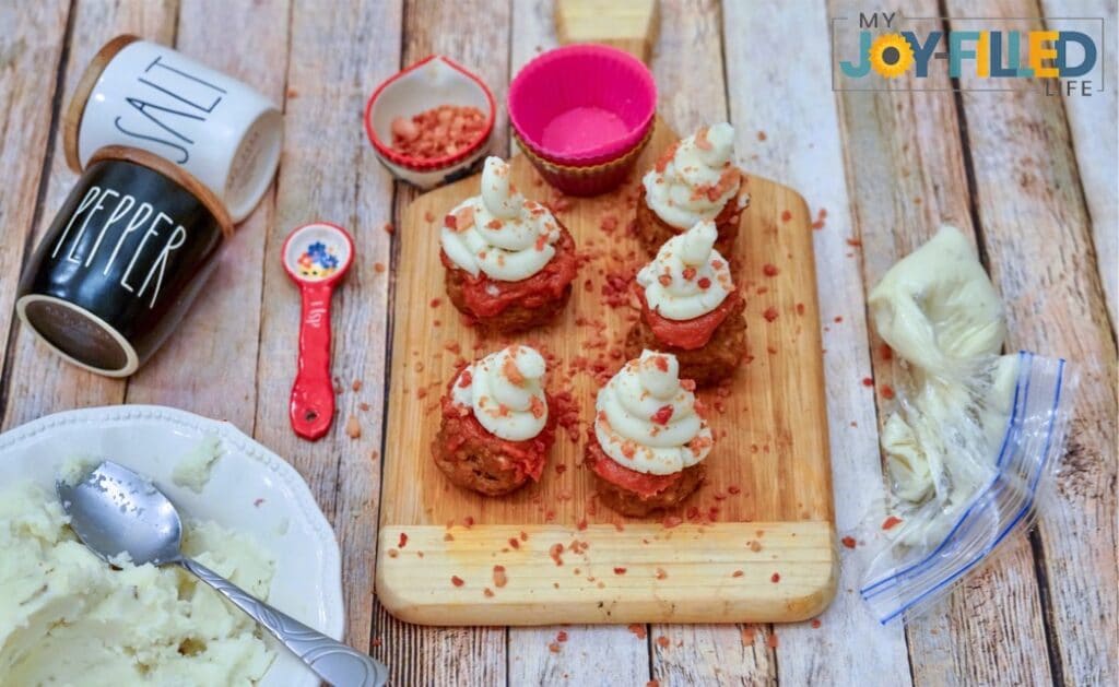 sprinkling bacon bits on meatloaf muffins