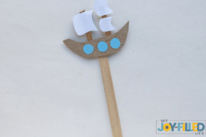 gluing the popsicle stick to the ship