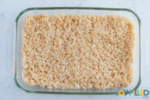 adding the rice krispie treats to dish